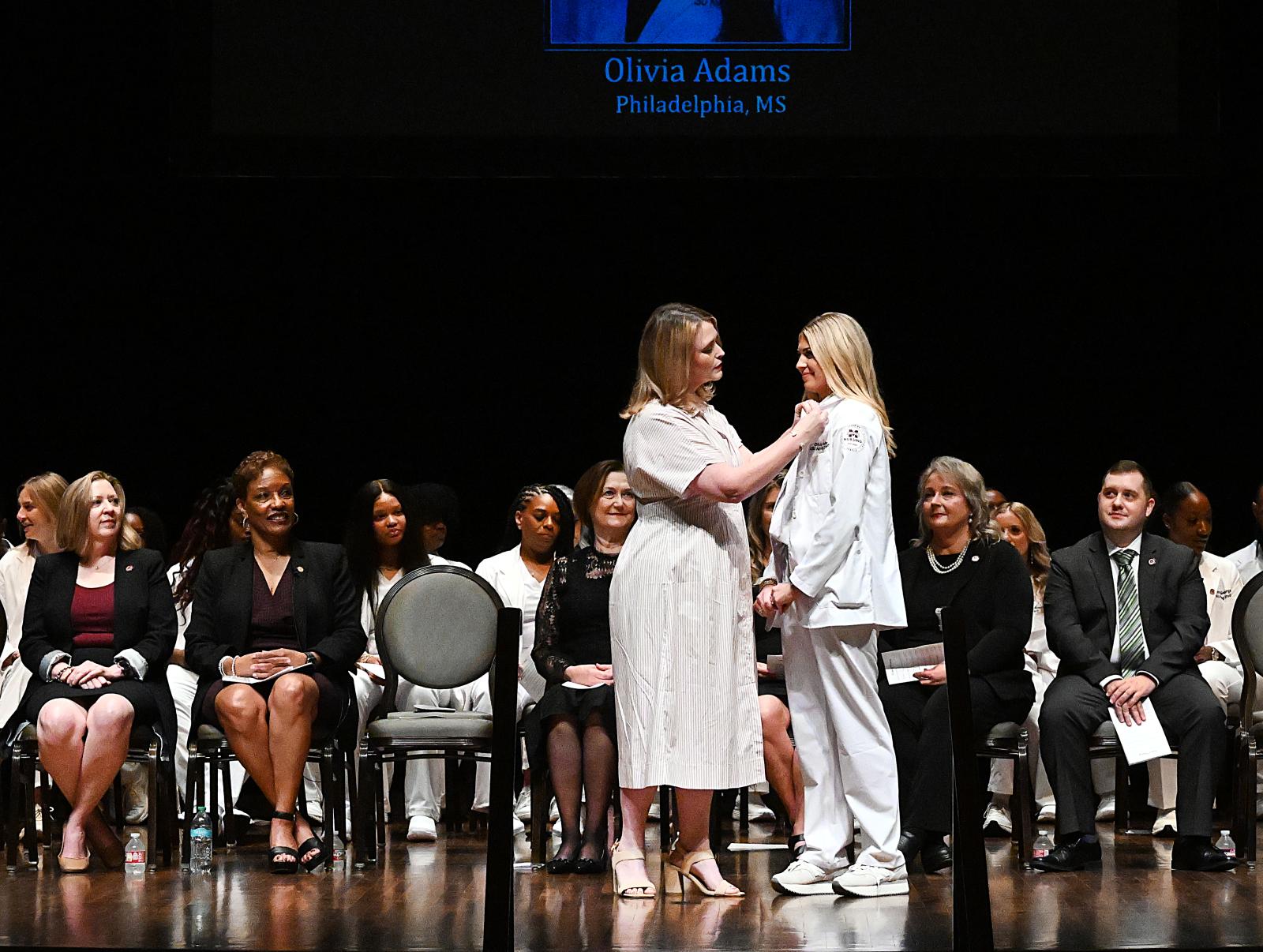 Kayla Carr, Mississippi State University-Meridian professor of nursing, pins graduate Olivia Adams of Philadelphia at Thursday&#039;s [Aug. 7] inaugural Master of Science in Nursing pinning and graduation ceremony. (Photo by Marianne Todd)
